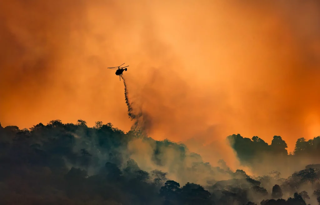 Firefighting helicopter operating during active wildfire detected and mapped by GESat hyperspectral satellite data for insurance risk prediction